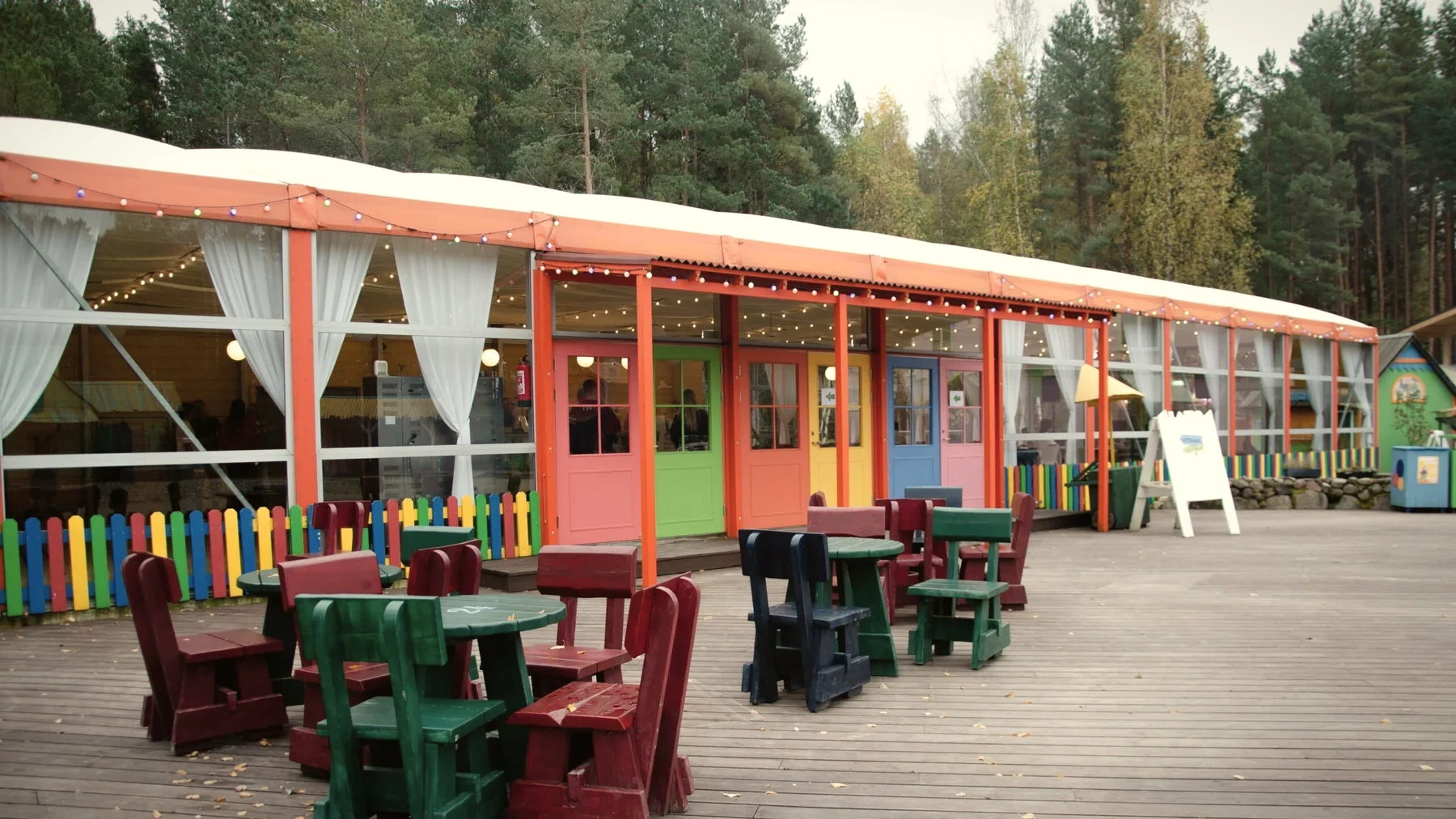 Lottemaan ruokapaikan värikkäät pöydät ja terassi